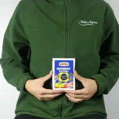 Osoba w zielonej bluzie trzyma opakowanie środka grzybobójczego SYLLIT. Preparat przeznaczony jest do ochrony drzew owocowych.