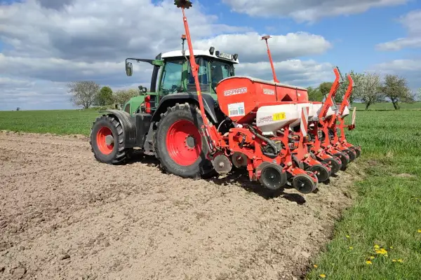 Zielony traktor z siewnikiem Gaspardo na polu. Idealny czas, by zasiać kukurydzę i cieszyć się plonami.